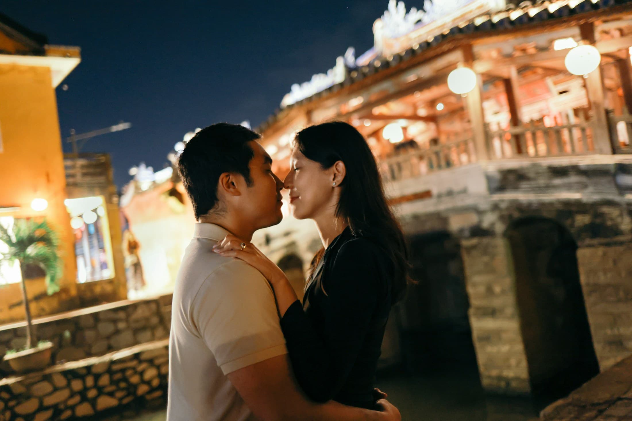 Couple embracing on a bridge at night